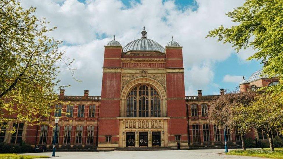 Red-brick academic building under a bright sky